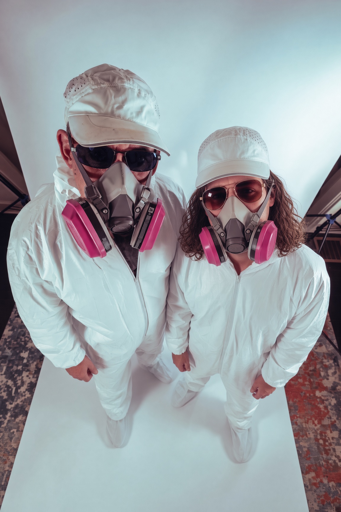 Joel and Ian photographed from above in white suits and respirators